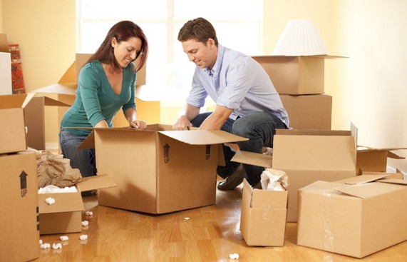 Couple Packing Boxes Together before Moving